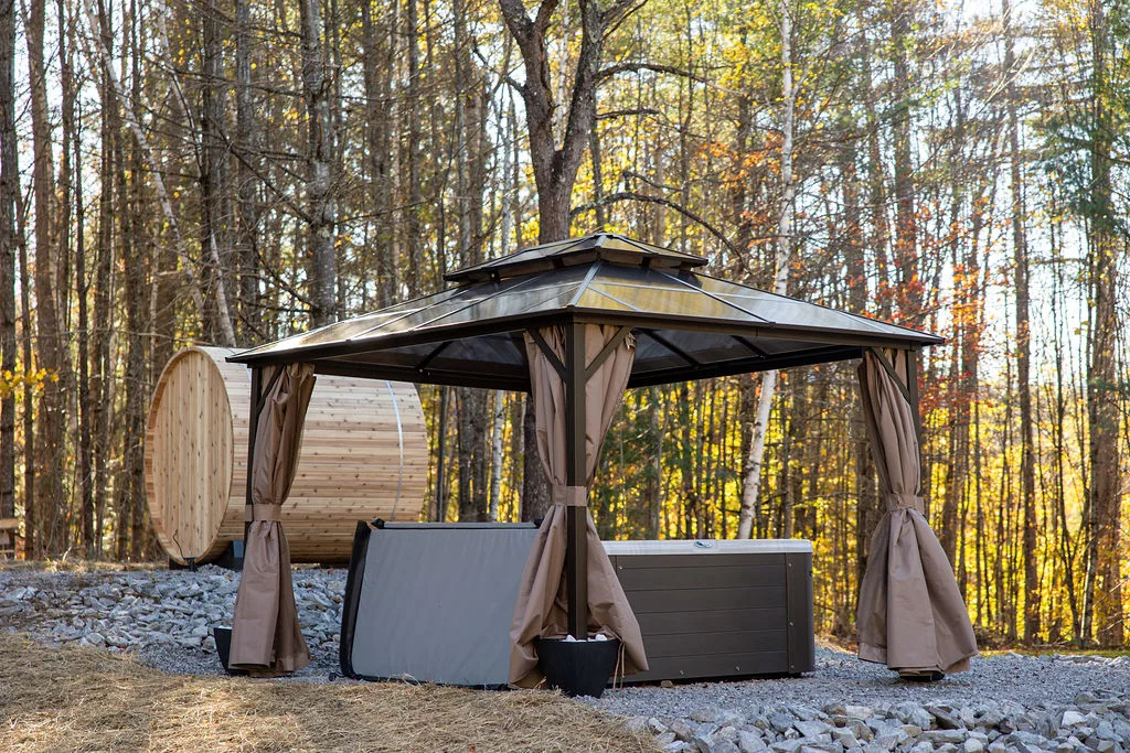 The cedar barrel sauna and private hot tub under the trees